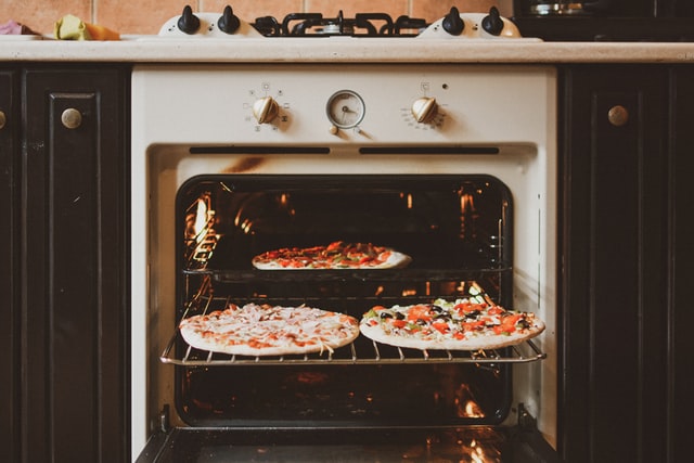 gambar 3 piring pizza di dalam oven gas